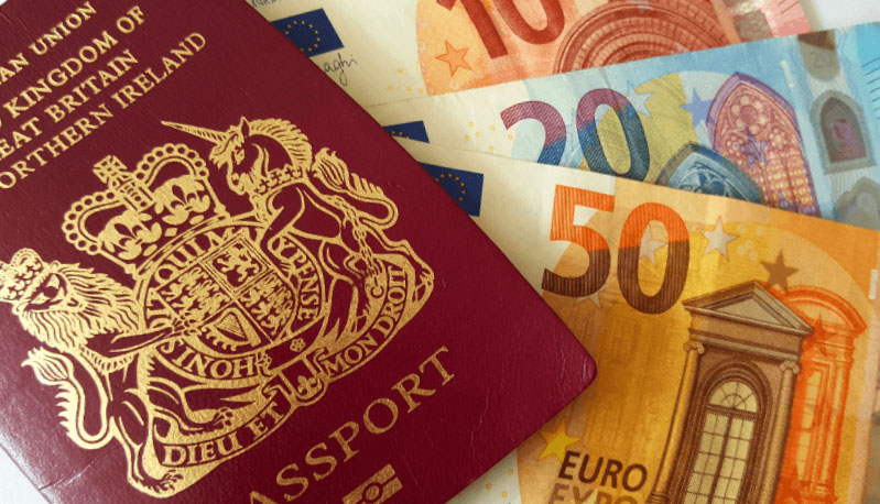 A picture of a British passport and Euro notes