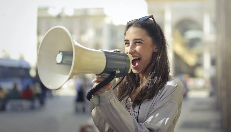 A picture of a person using a megaphone to pronounce something