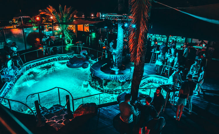 A picture of Mandala discotec at night with a swimming pool