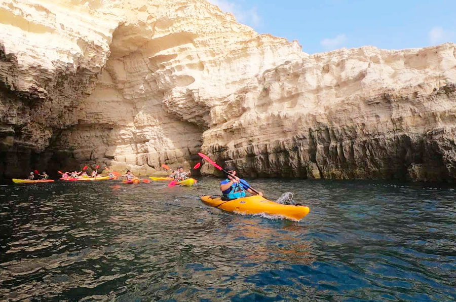 A picture of a group of people kayaking near a cave in Cabo De Gata